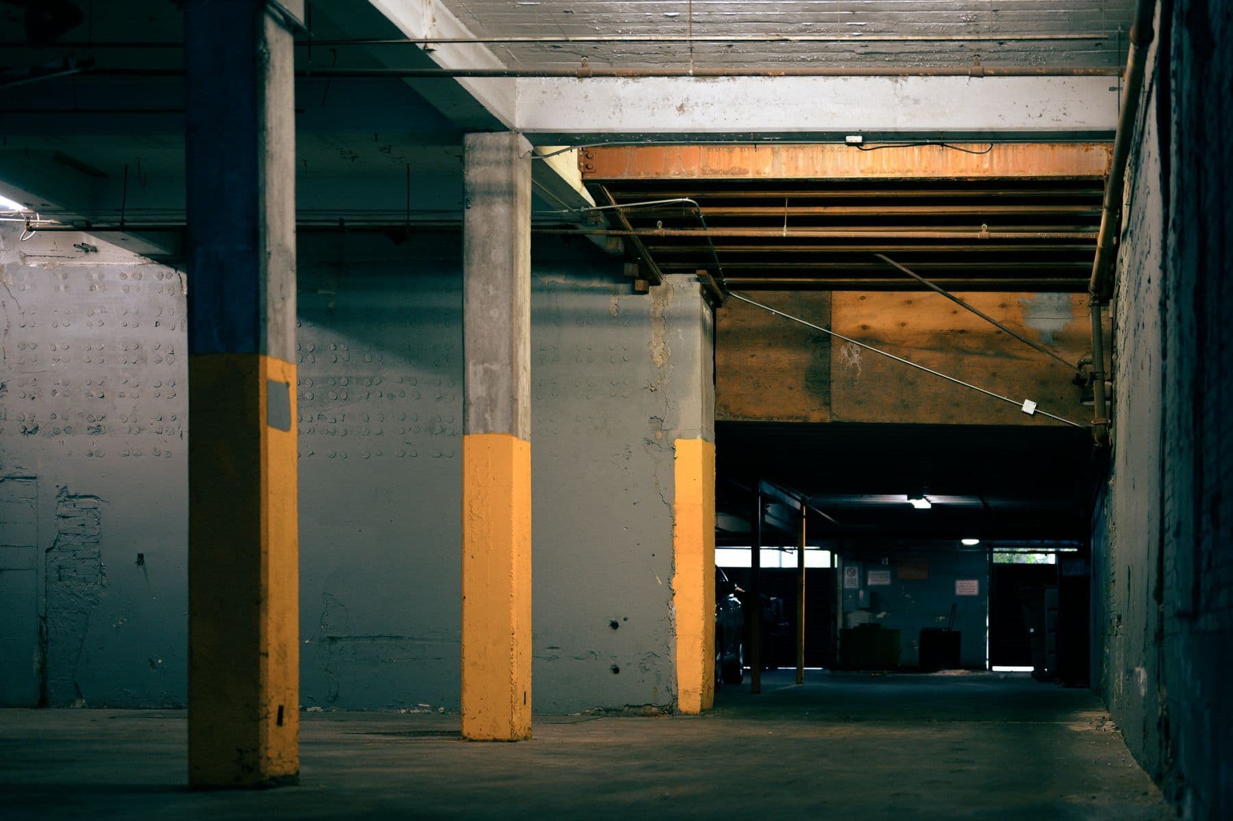 A concrete parking structure with gray columns whose lower sections are painted yellow.